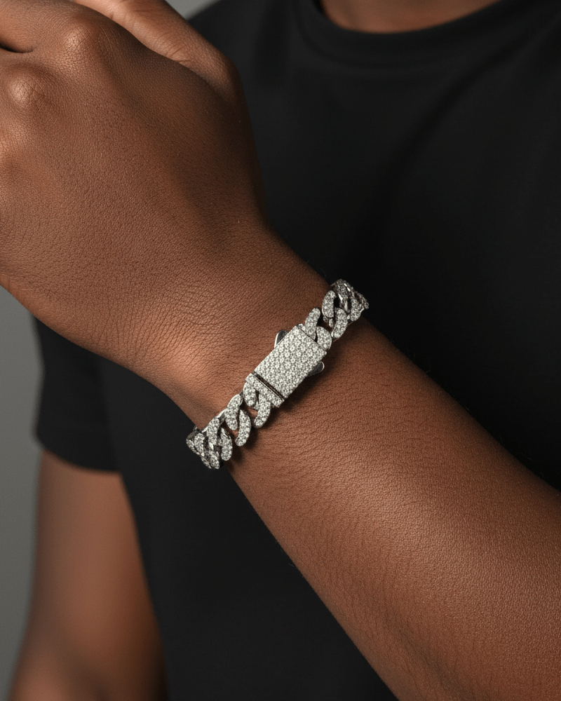 Silver chain bracelet on a person's wrist with a neutral background