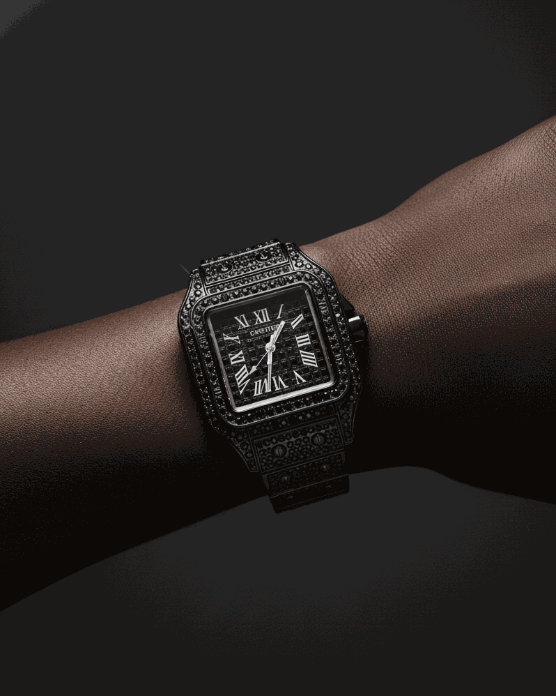 Luxury black watch with diamond accents on a wrist against a dark background