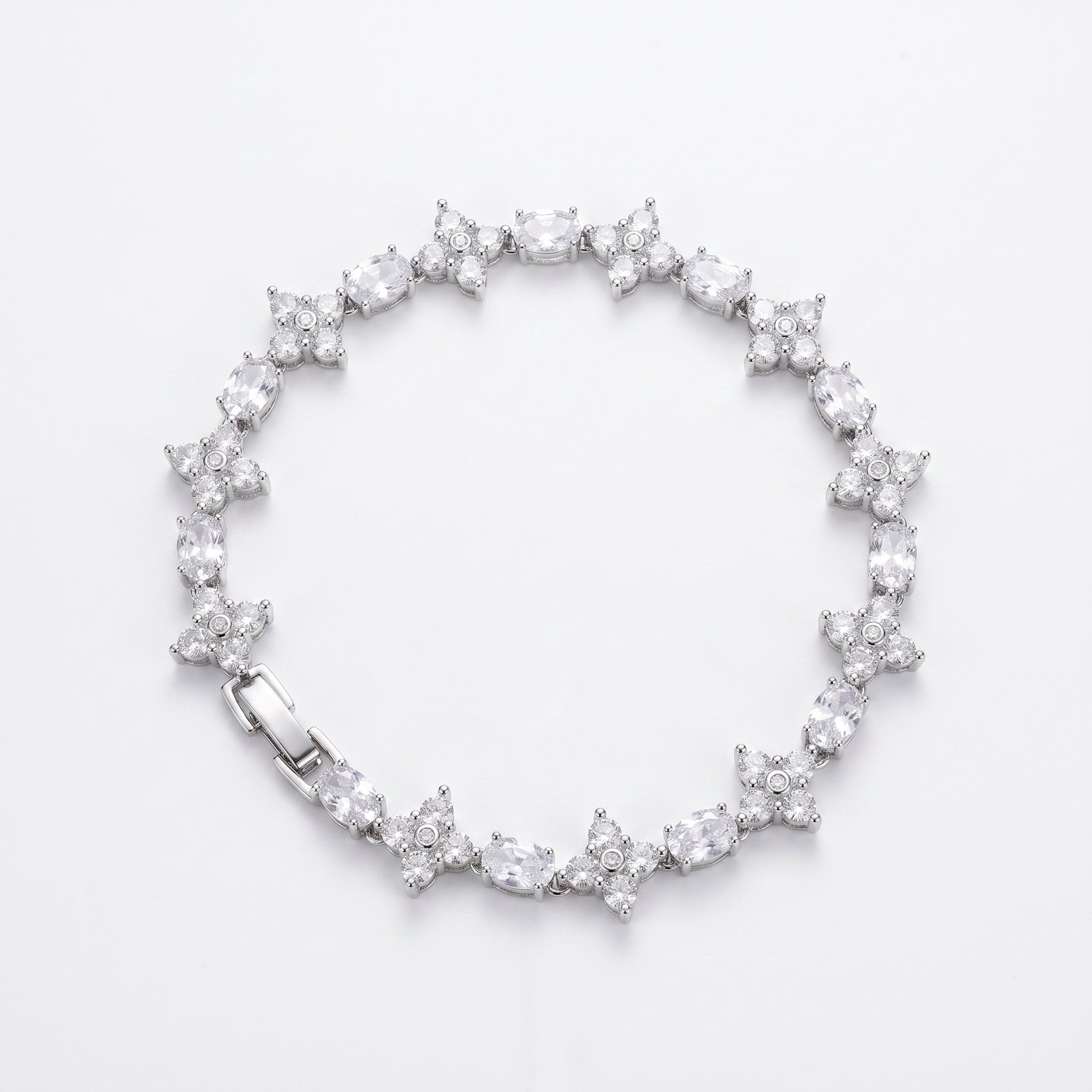 A silver tennis bracelet featuring a continuous line of starburst clusters of clear gemstones, displayed on a clean white background.