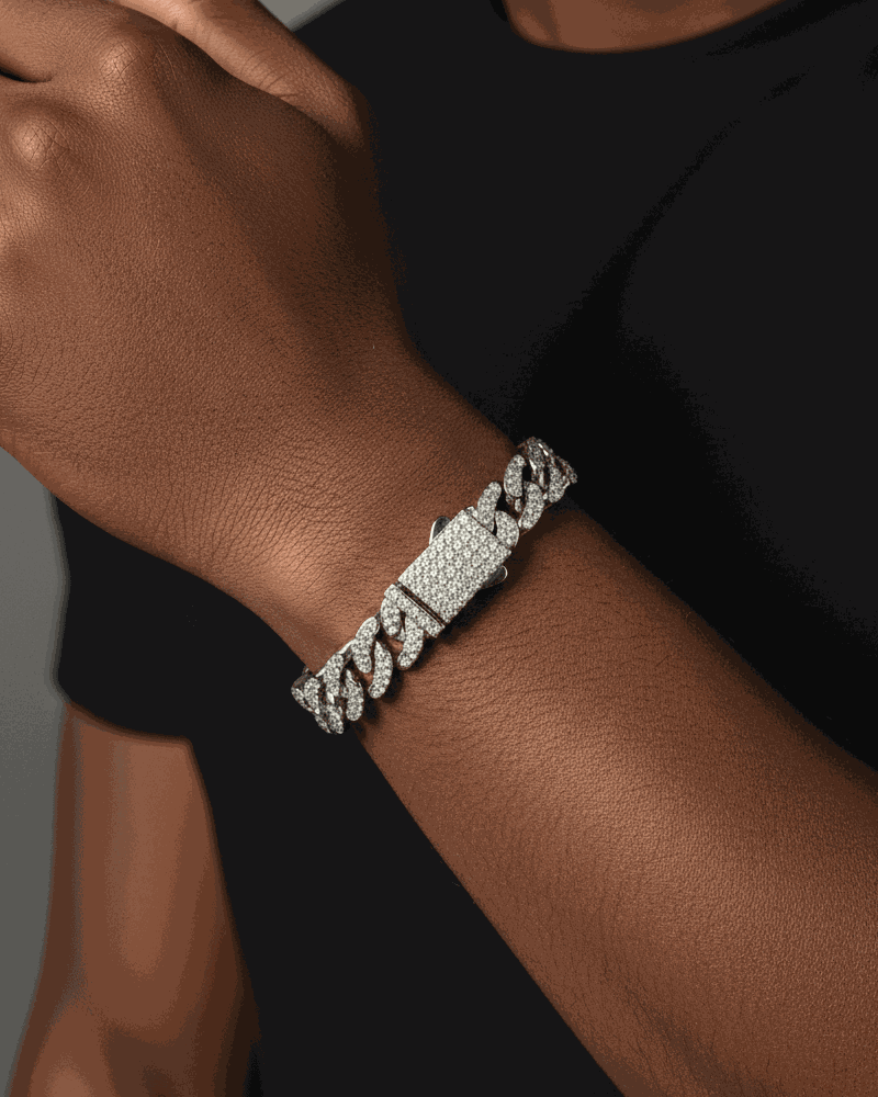 Silver chain bracelet on a person's wrist with a neutral background