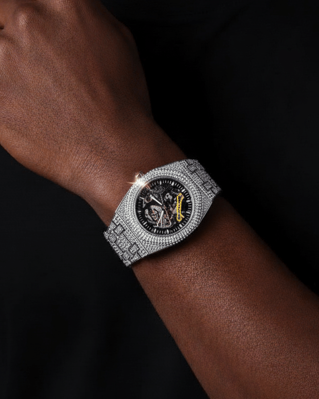 Person wearing a silver watch with a black face on a dark background